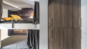 A bunk bed with a headboard, a wardrobe with a mirror, and a wall with a map design. - Metro Hostel (Kyiv)