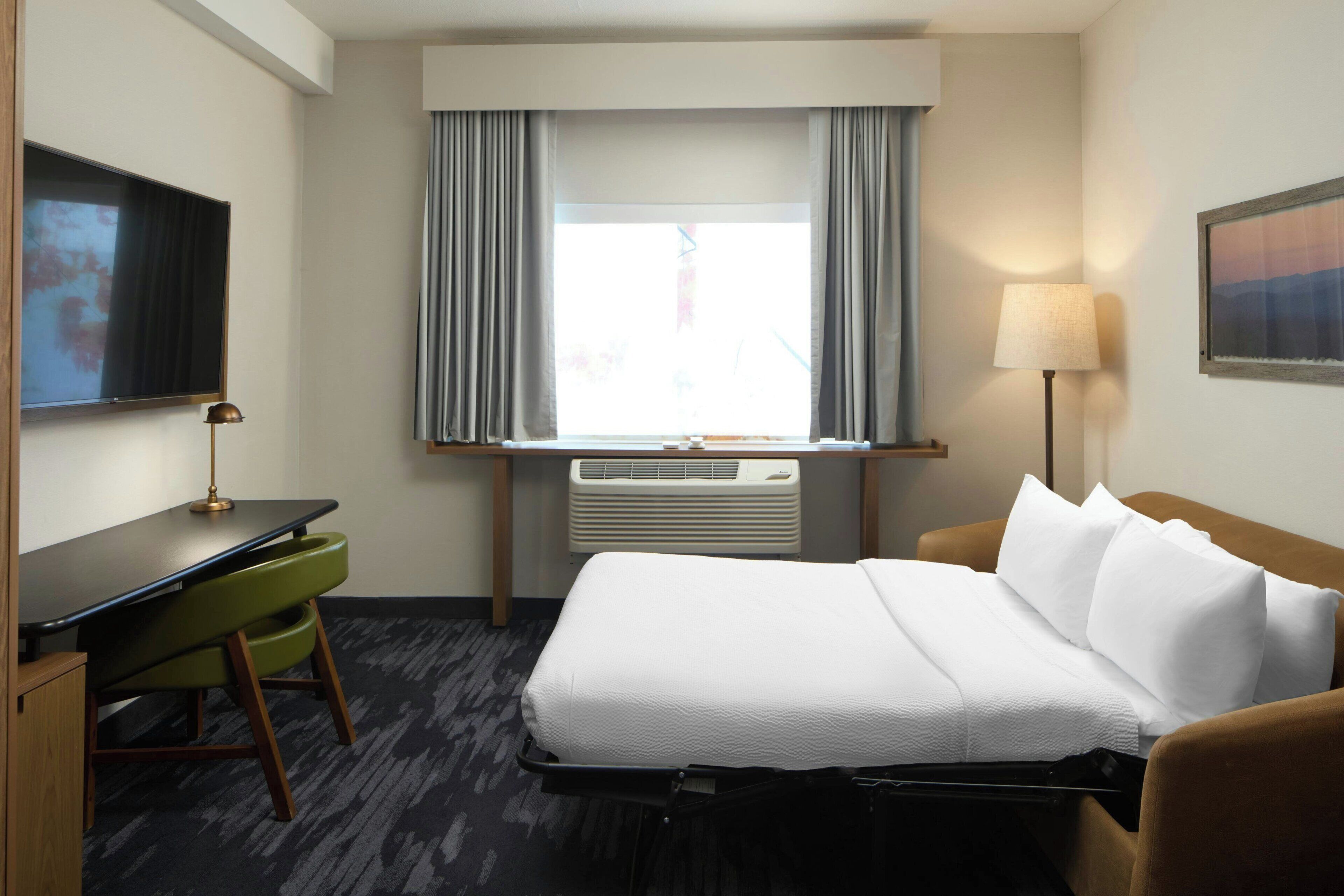 Una scrivania, postazione laptop, tende oscuranti, ferro/asse da stiro