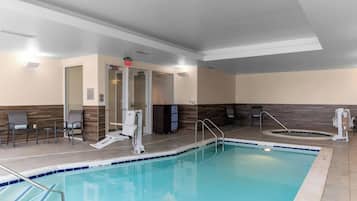 Zona de piscina con silla de socorrista, escalera de piscina y banco.