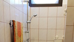 Un bany amb vàter, rentapel orells i dutxa.