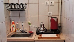Cuina compacta amb un rentaplat, una cafetera i un armari petit.
