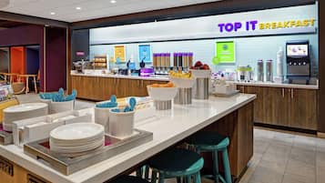 A breakfast area with a counter, stools, and various food items.