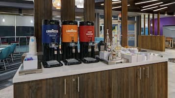 Una barra con tres dispensadores de agua, identificados como 'Lavazza' y 'Agua Caliente'.