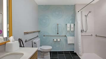 A modern bathroom with a toilet, sink, and shower.
