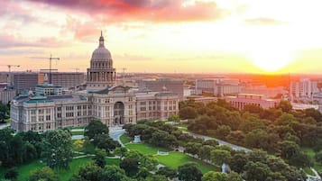 A large government building with a prominent dome, surrounded by green spaces and modern buildings.