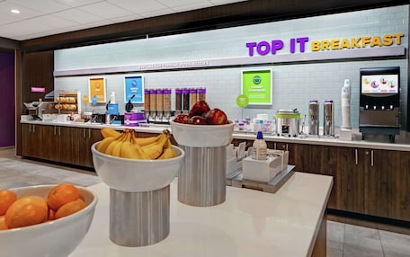 A breakfast buffet area with various food items and a yogurt and cereal display.