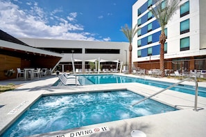 Una piscina al aire libre, sillones reclinables de piscina