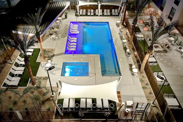 Una piscina al aire libre, sillones reclinables de piscina