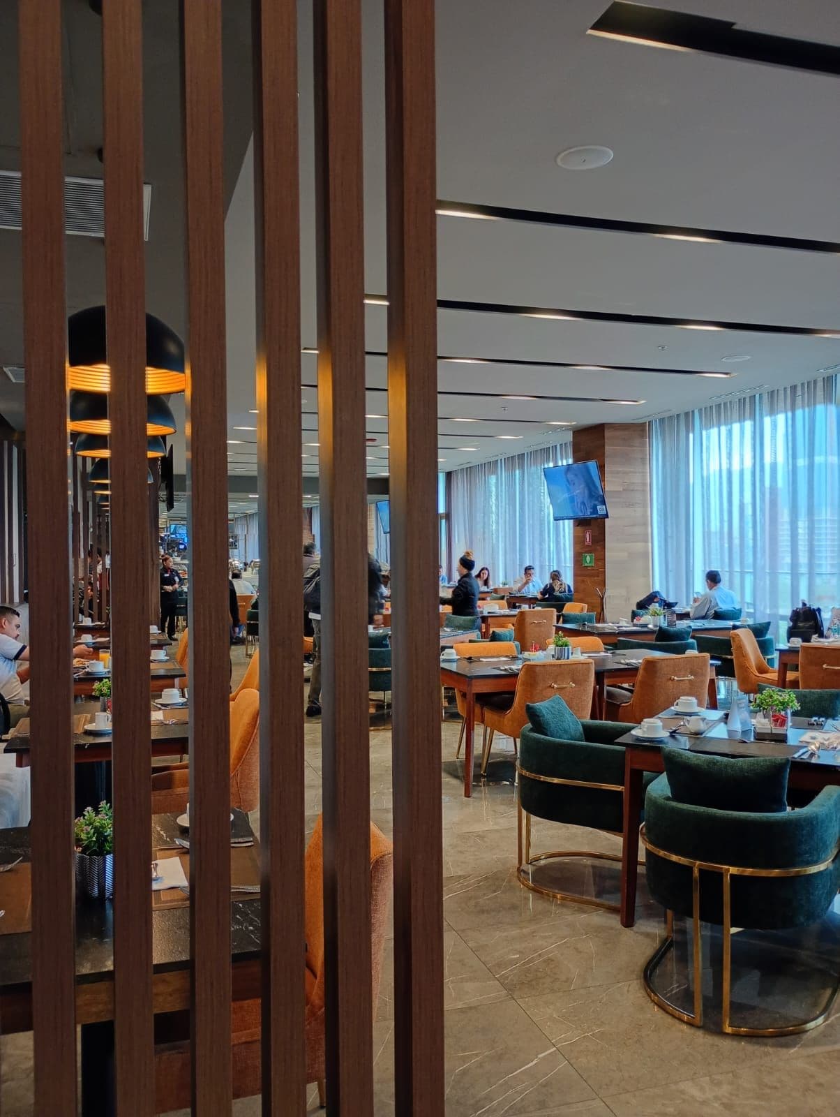 A modern dining area with wooden partitions, tables, and chairs.