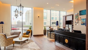 A hotel lobby with a large window, a reception desk, a sofa, and a coffee table.