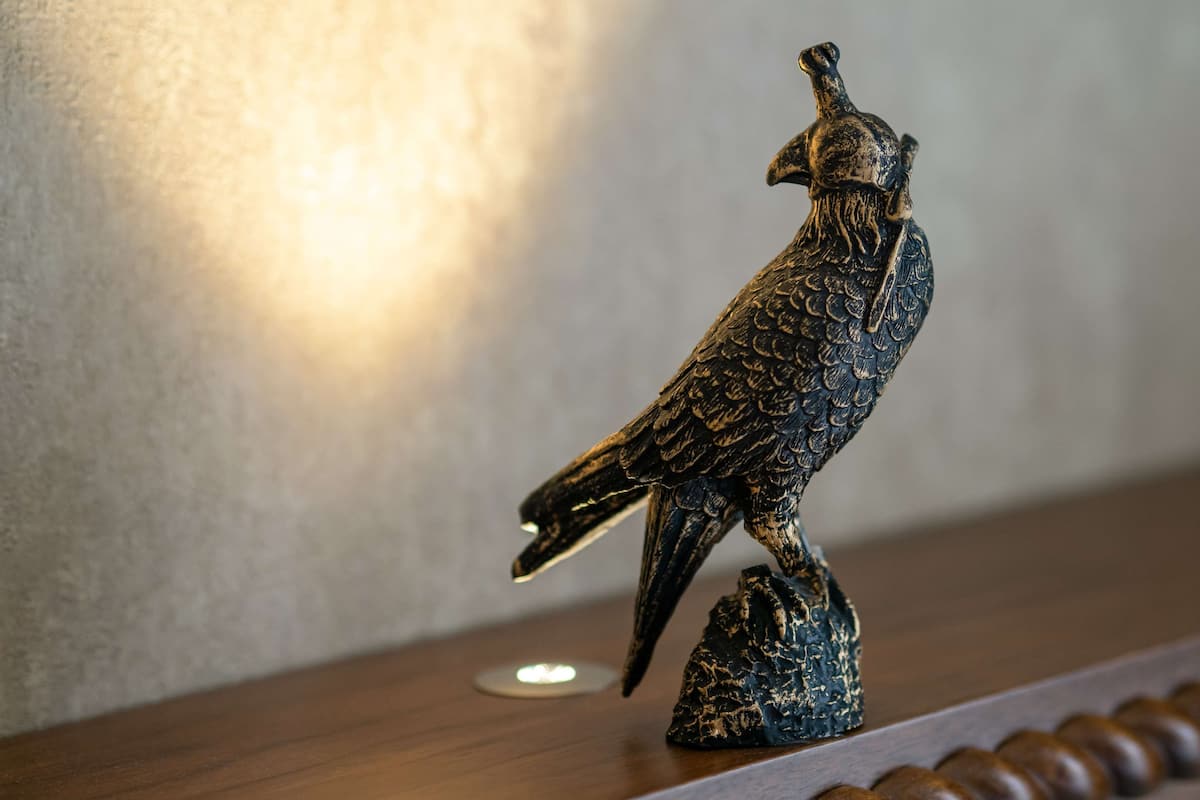 A bird-shaped sculpture on a wooden shelf.