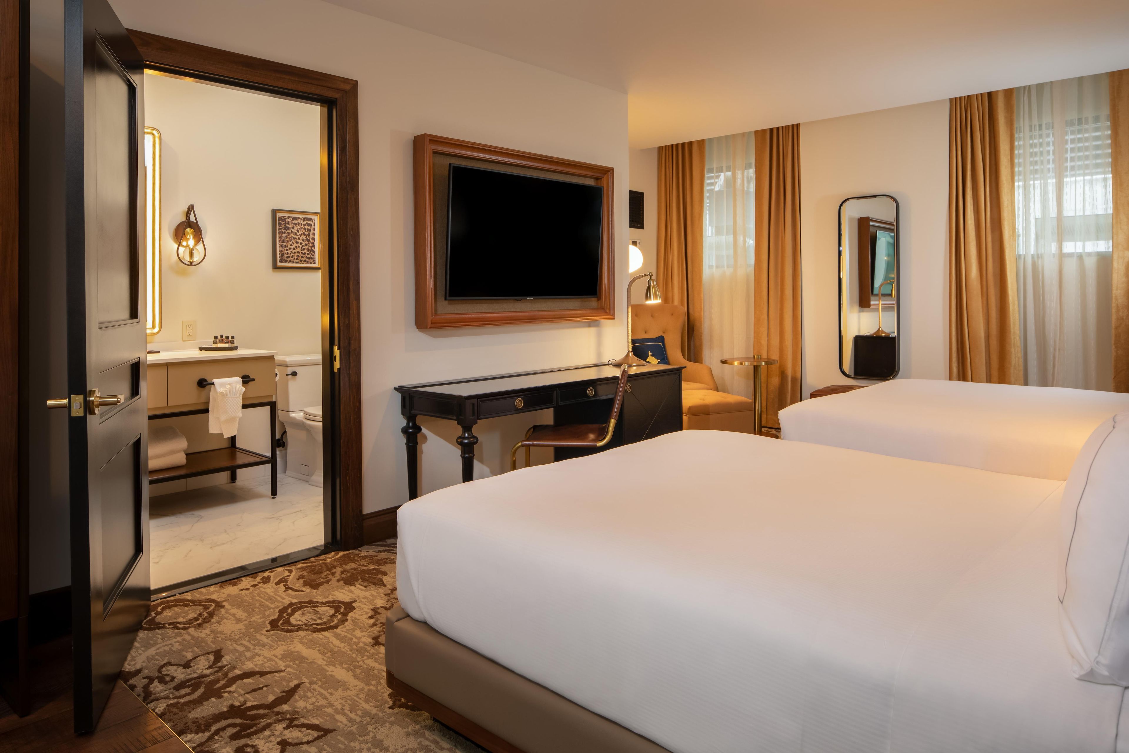 Une chambre d’hôtel avec un lit, un bureau, une télévision et une salle de bain.