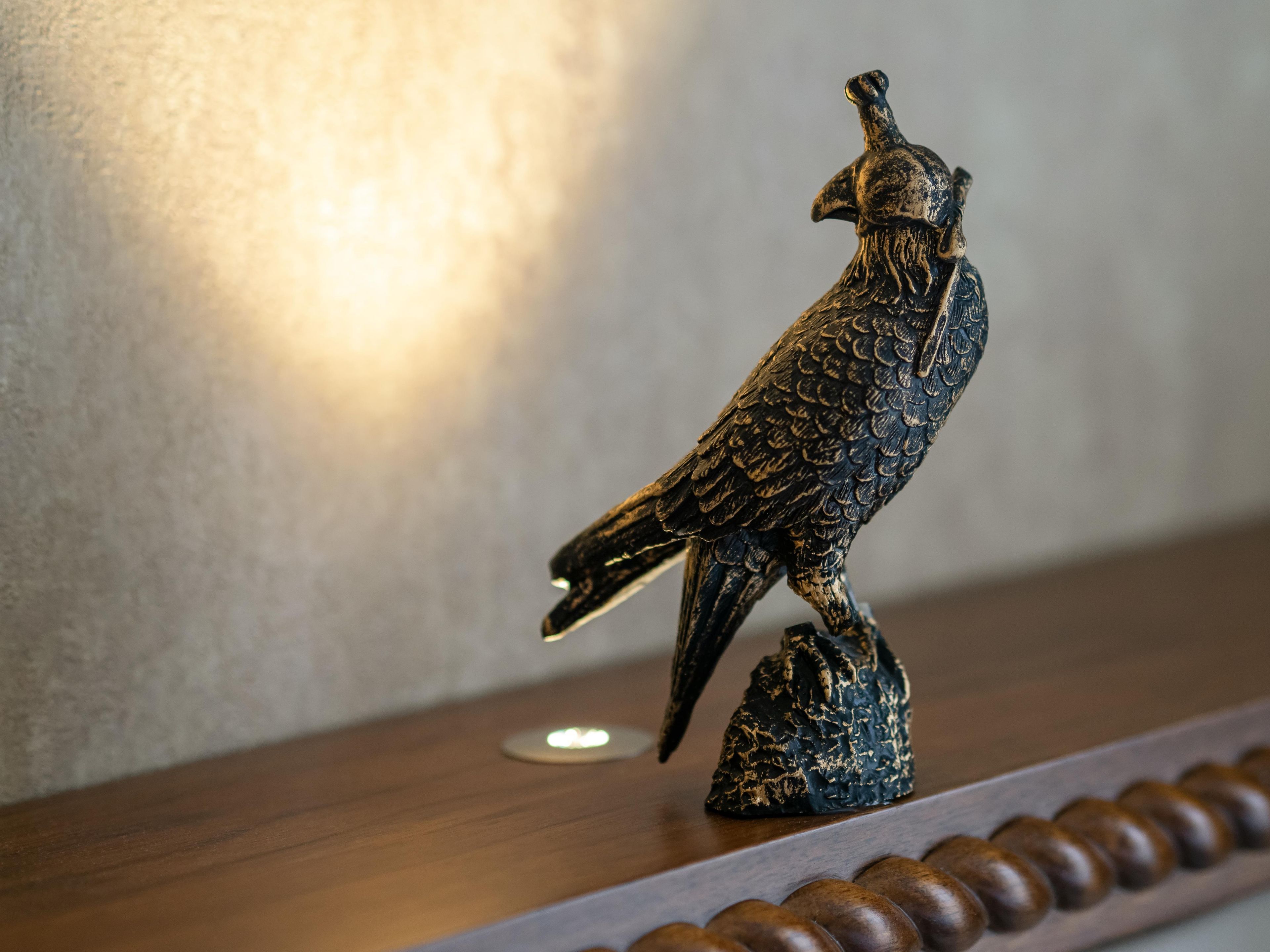 Una escultura con forma de pájaro sobre una superficie de madera.