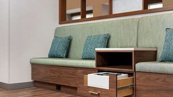 Ein modernes Sofa mit Stauraumschubladen und einem Holznachttisch.