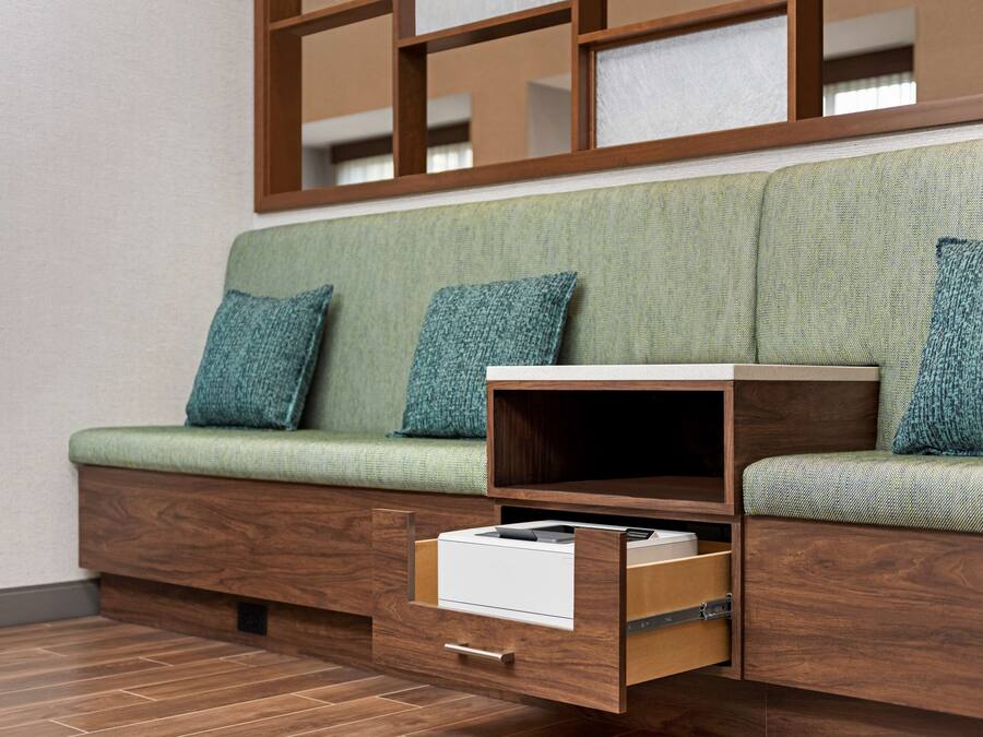 Ein modernes Sofa mit Stauraumschubladen und einem Holznachttisch.