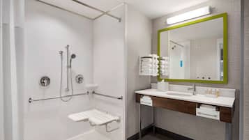 A modern bathroom with a walk-in shower, a vanity with a mirror, and a toilet.
