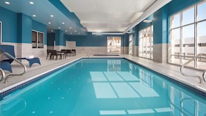 An indoor swimming pool with blue walls and a clear view of the outside through large windows. - Hampton Inn & Suites by Hilton Kelowna Airport (Kelowna)