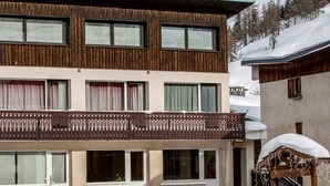 Un bâtiment à deux étages, doté d’une façade en bois, de nombreuses fenêtres et d’un balcon.
