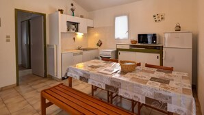 A compact kitchen with a dining area, a microwave, a refrigerator, and a sink. - Chalet in Usson-en-Forez with fireplace, pets allowed and terrace (Usson-en-Forez)