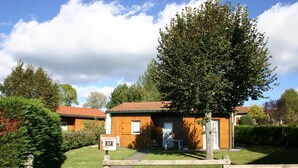 A wooden cabin with a red roof, surrounded by greenery and a wooden fence. - Chalet in Usson-en-Forez with fireplace, pets allowed and terrace (Usson-en-Forez)
