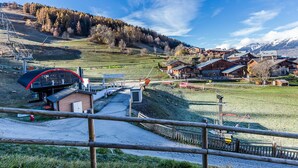 A mountain village with traditional wooden houses, a ski lift, and a clear view of the surrounding mountains. - Cozy Studio for 2 with Terrace, Ski-in/Ski-out, Close to Shops - Montchavin La Plagne (La Plagne Montchavin Les Coches)