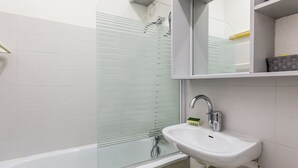 A modern bathroom with a glass shower enclosure, a white sink, and a mirror above the sink. - Cozy Studio for 2 with Terrace, Ski-in/Ski-out, Close to Shops - Montchavin La Plagne (La Plagne Montchavin Les Coches)