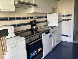 A modern kitchen with a microwave, coffee maker, sink, and oven.