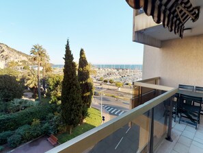 A balcony with a view of a marina and cityscape.