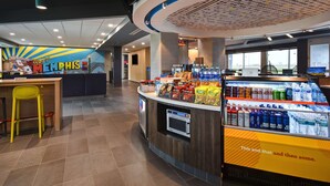 Un patio de comidas con mostrador, mesas y expendedor automático.