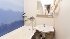 A bathroom with a bathtub, a sink, and a mirror. There are toiletries on the shelf. - MalinaApt Sea Place (Kyiv)