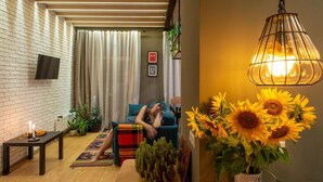 Een gezellige woonkamer met een bank, een salontafel en een hanglamp.