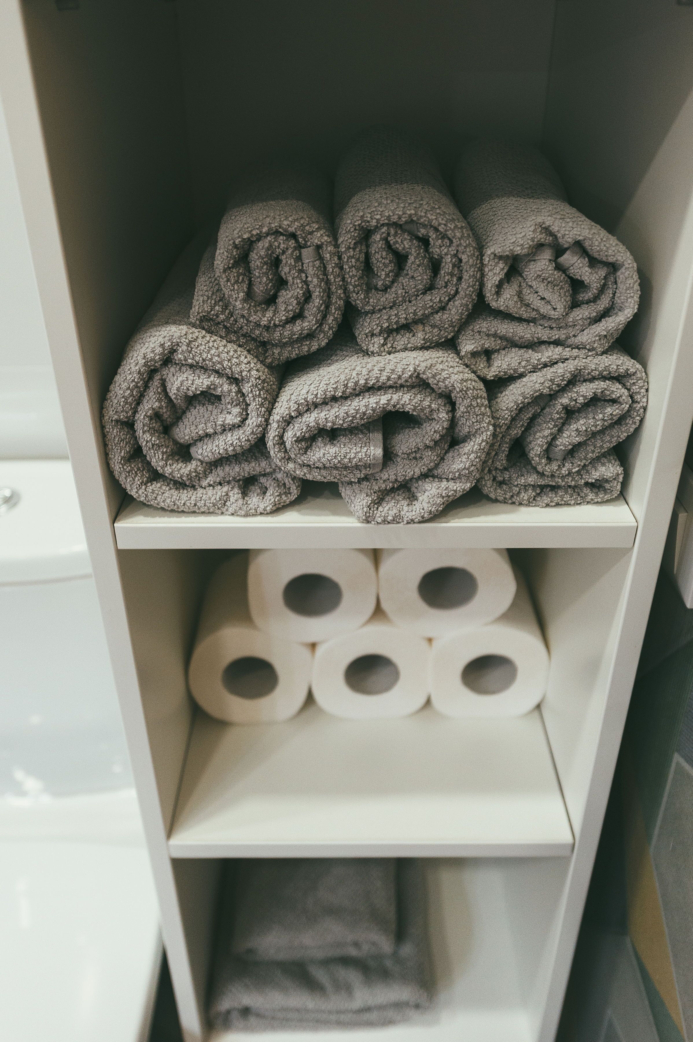 A storage area with neatly rolled towels and toilet paper.