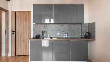 Una cocina moderna con gabinetes grises, una encimera de granito y un horno empotrado.