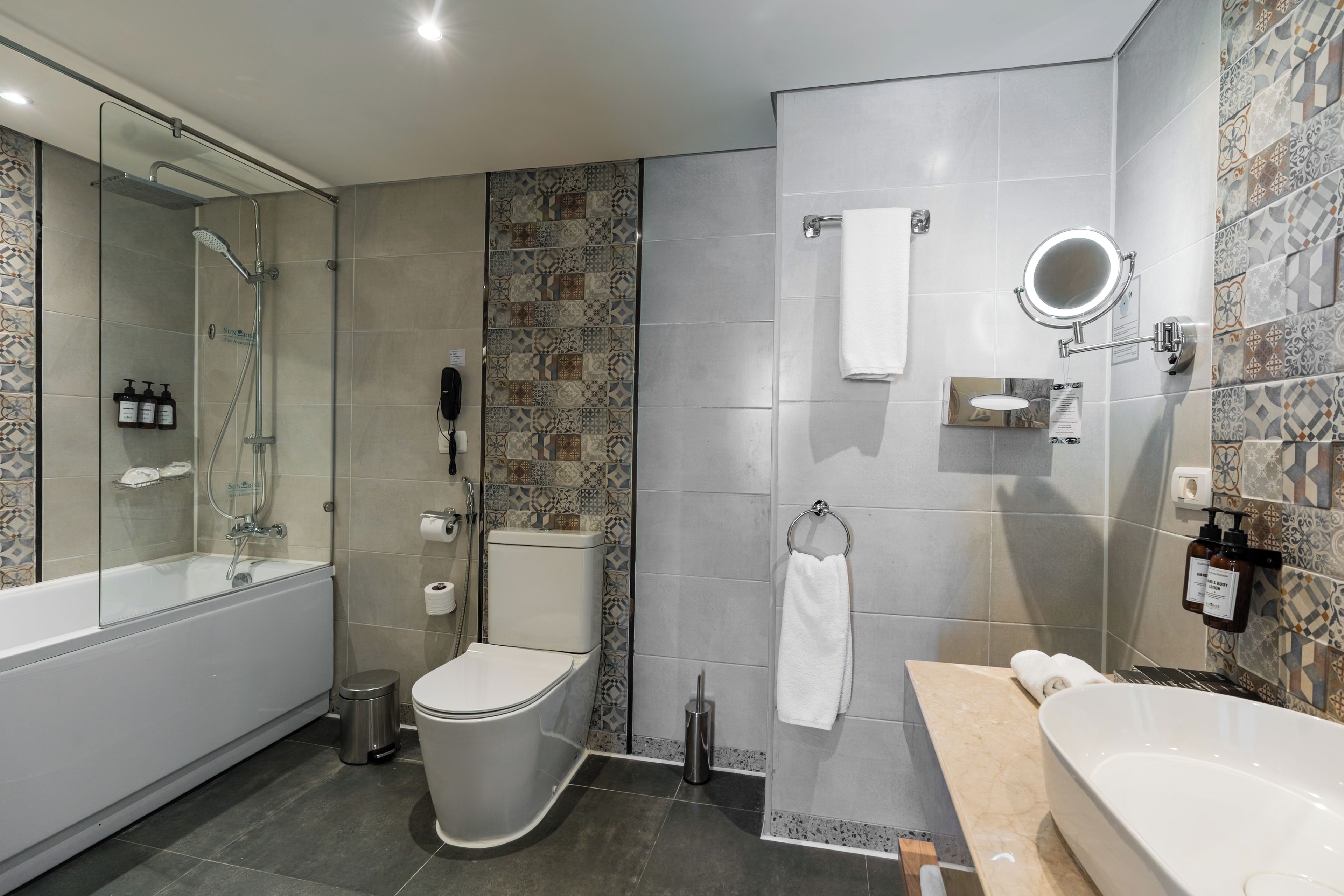 Een moderne badkamer met een douchecabine, een toilet en een bad.