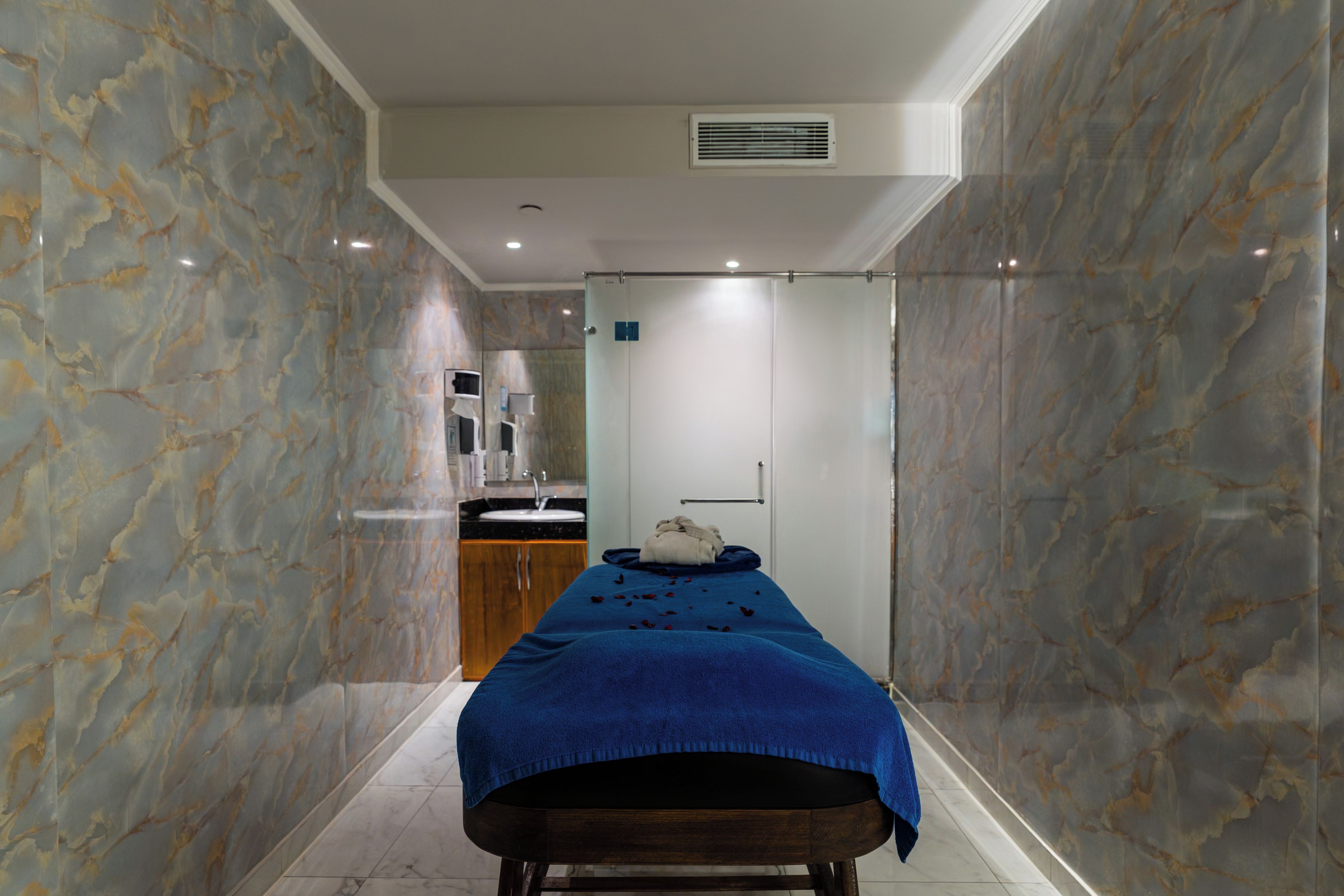 A room with a bed, a sink, and a mirror.