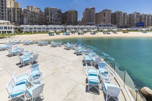 Relax by the pool with a view of the ocean and access to the sandy beach.