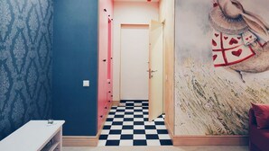 A hallway with patterned wallpaper, a checkered floor, and a mural of a bird. - MalinaApt Alice in Wonderland (Kyiv)