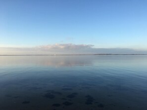 A calm body of water with a distant shoreline and a clear sky. - Heltoften Bed & Breakfast (Nykobing Mors)