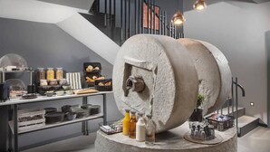 A modern kitchen with a large stone mixer, various food items, and a staircase in the background. - Terra Residence (Labin)