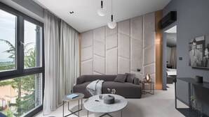 A modern living room with a sofa, coffee table, and pendant lights. - Terra Residence (Labin)