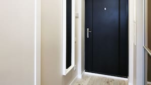 Un pasillo con una puerta negra y una puerta blanca.
