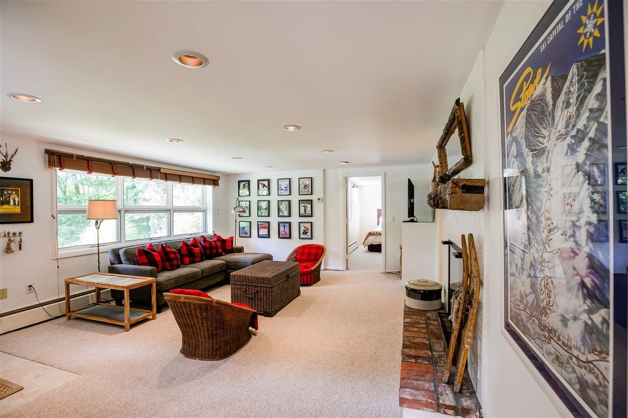A spacious living room with a sofa, two armchairs, a coffee table, and a fireplace.