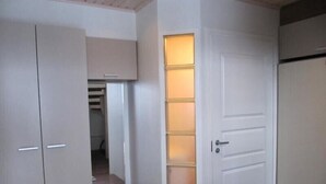 A hallway with a wardrobe, a door with a light panel, and a refrigerator. - Rukako JYRKKÄLÄ A (Kuusamo)