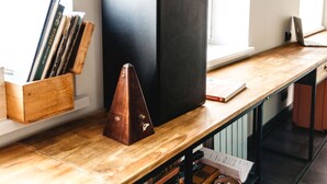 A wooden desk with a large black monitor, a wooden speaker, and a laptop. - MalinaApt Mushka (Kyiv)