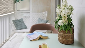 A reading area with a table, a book, a cup, and a potted plant. - Rastoni Athens Suites near Acropolis (Athens)