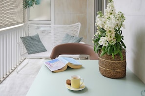 Relax in a serene space with a comfortable chair, a potted plant, and a warm radiator.