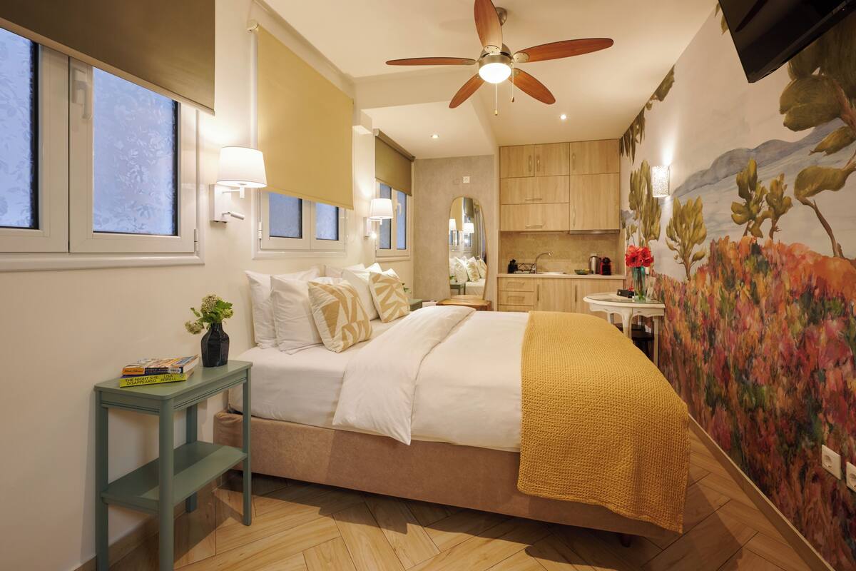 A bedroom with a bed, bedside table, and a ceiling fan.