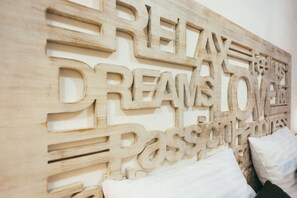 A wooden wall with carved text reading "RELAY DREAMS PASSION". - MalinaApt  Sophisticated red (Kyiv)