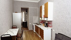 Eine kompakte Küche mit Essbereich, einem Backofen und einem Kühlschrank.