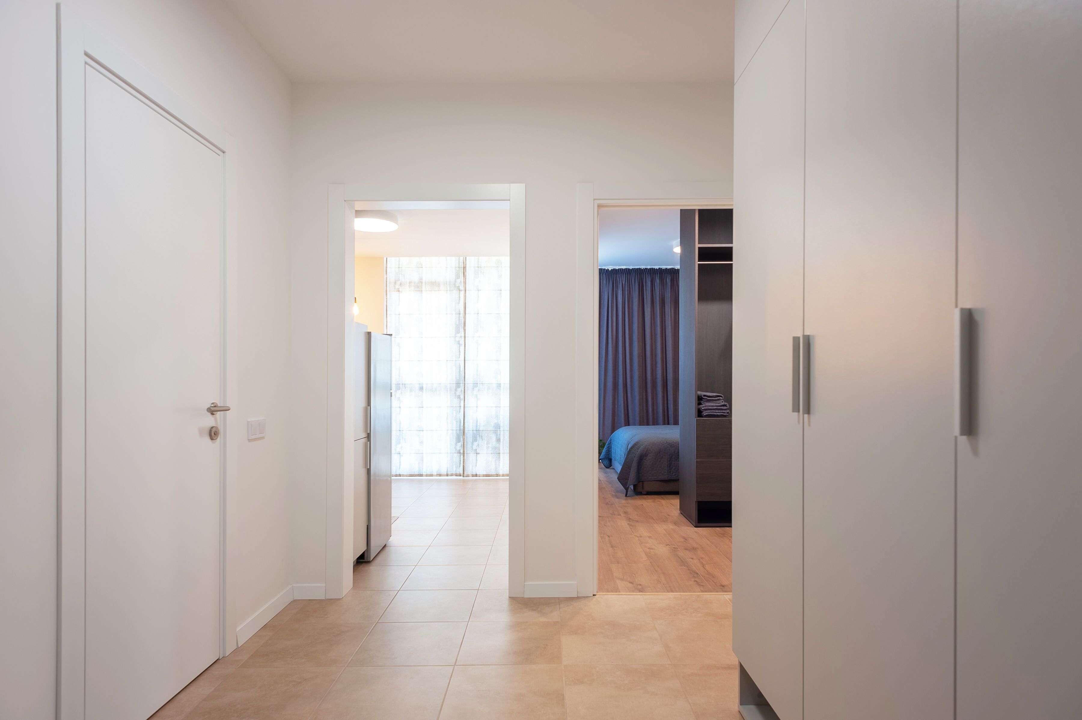 Un pasillo que conduce a un dormitorio con cama y armario.